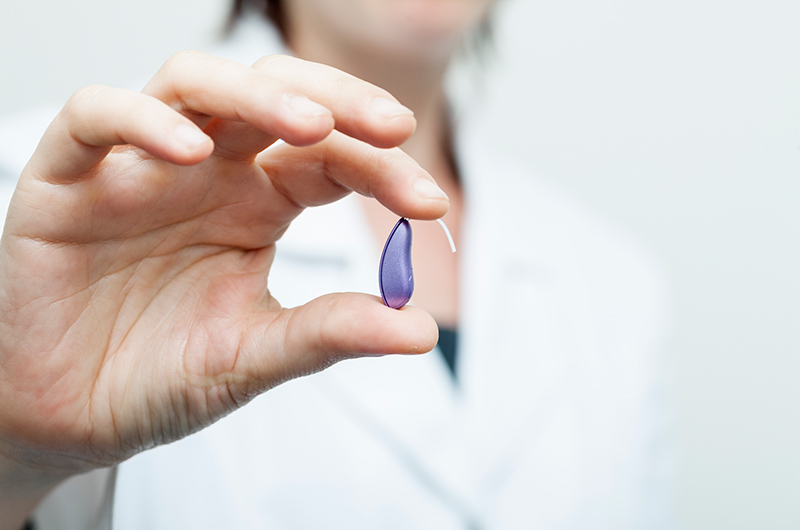 Female Doctor Holding Wireless Hearing Aid