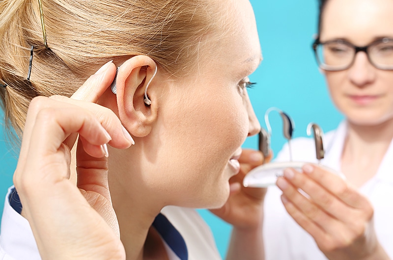 Woman Trying On Wireless Hearing Aid